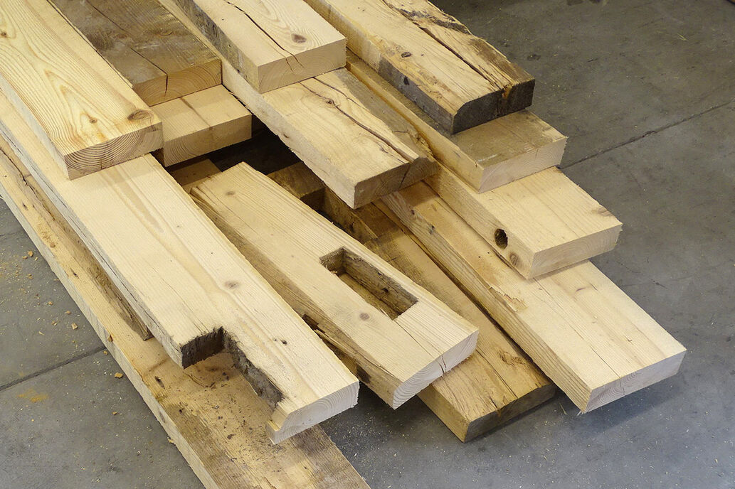 Am Boden der Prüfhalle der Holzforschung Austria gestapelte Altholzbretter.